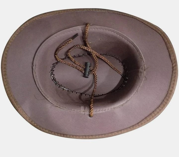 Brown wide-brim cowboy hat with braided band, stitched crown edge, and chin ties on white background
