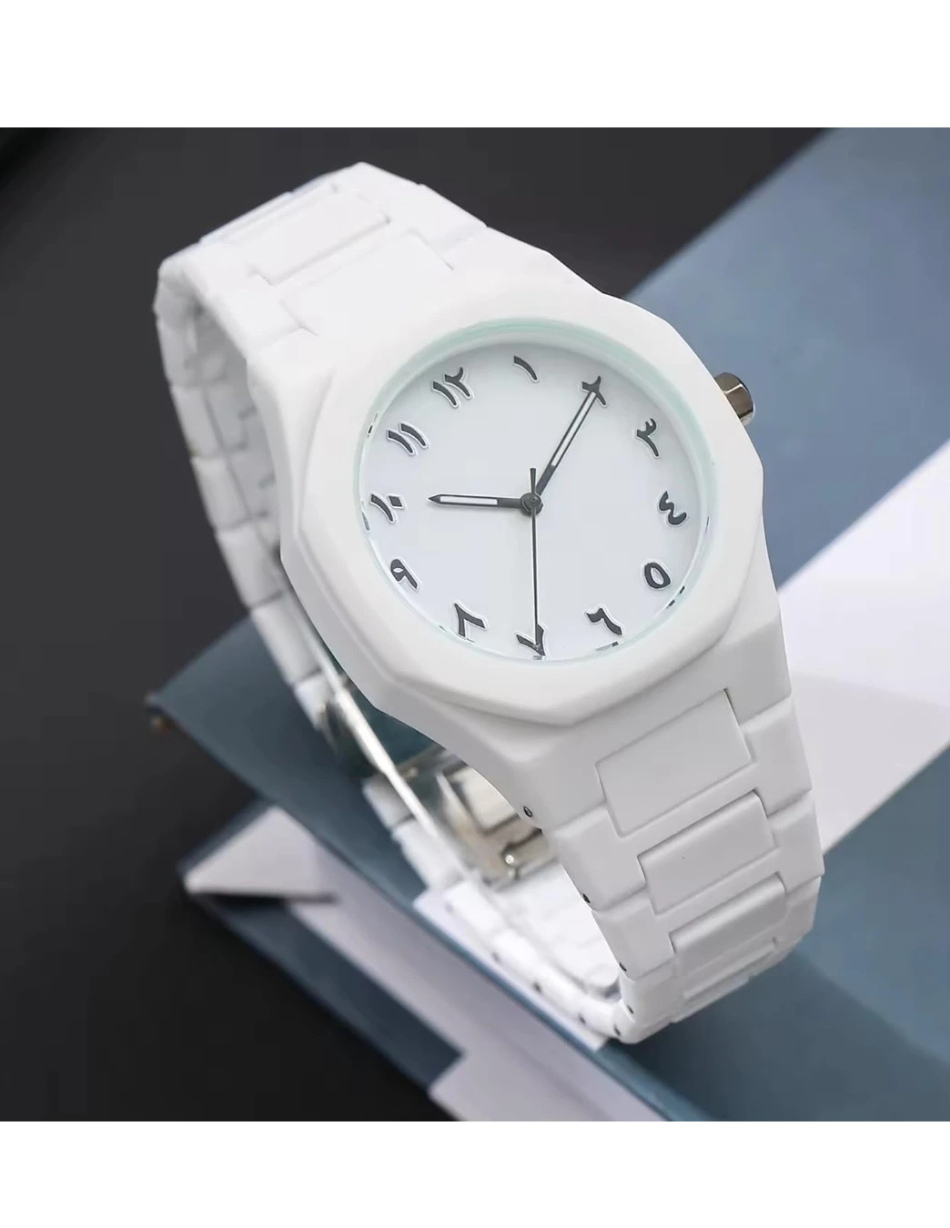 White analog wrist watch with black Arabic numerals and matching white linked strap