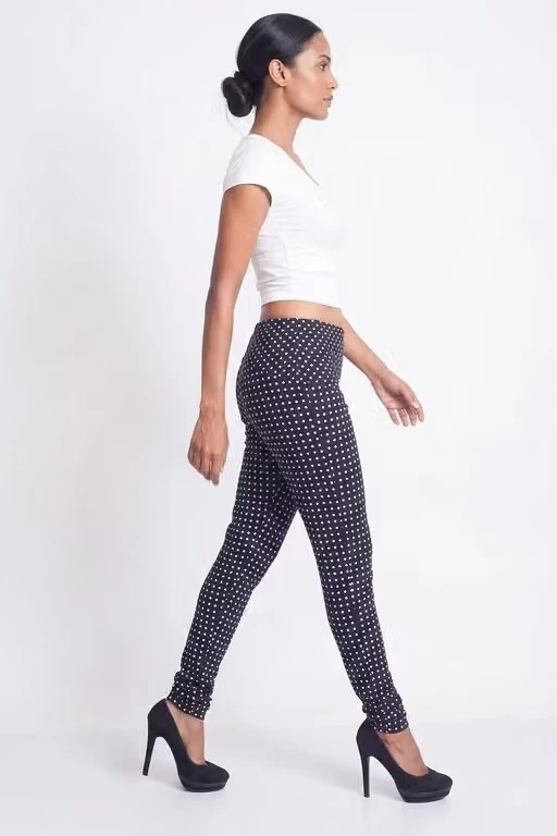 Side profile of navy leggings with white polka dots, showing the high-rise waist and tapered leg