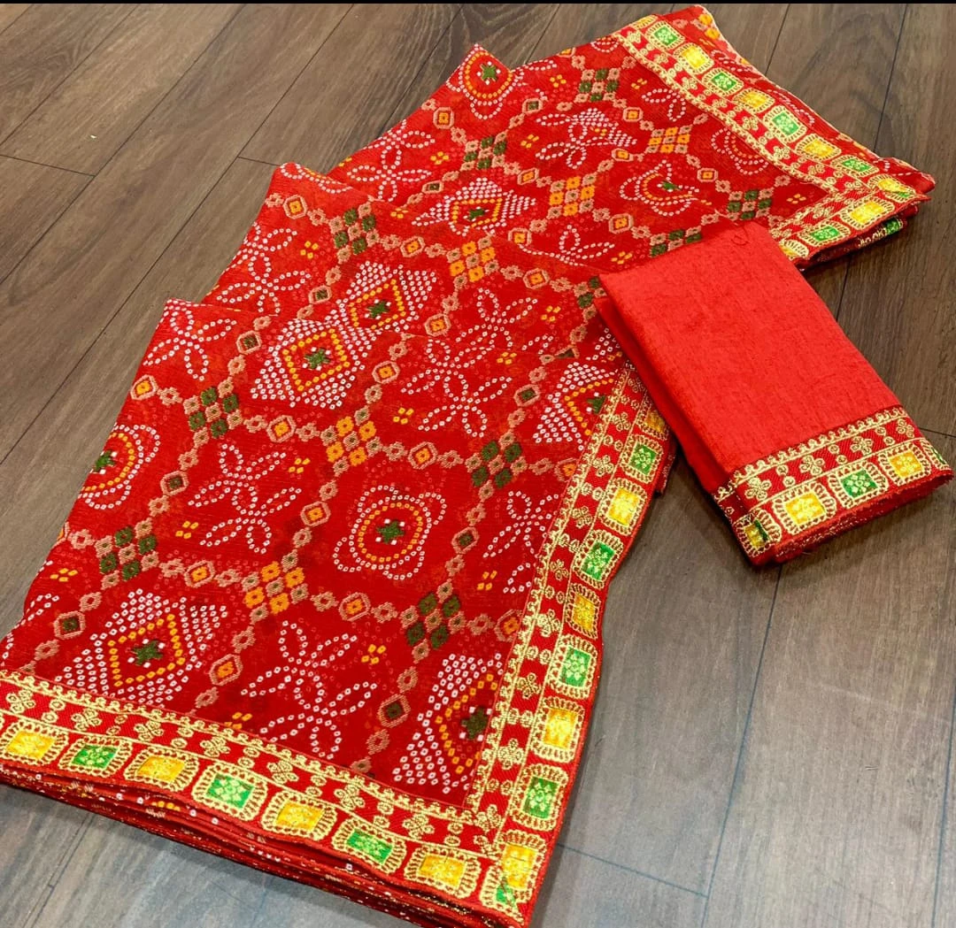 Angled view of the red saree on wooden floor showing bandhani-style motifs and folded blouse fabric