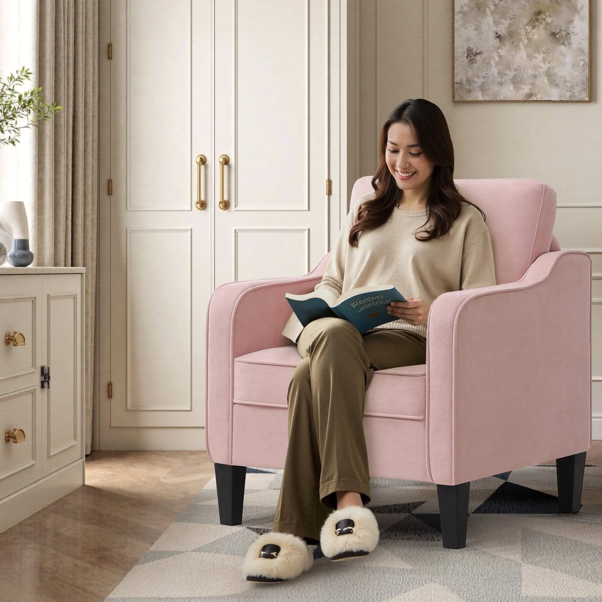 Pink armchair in use with a seated woman reading, showing scale and lounge setting