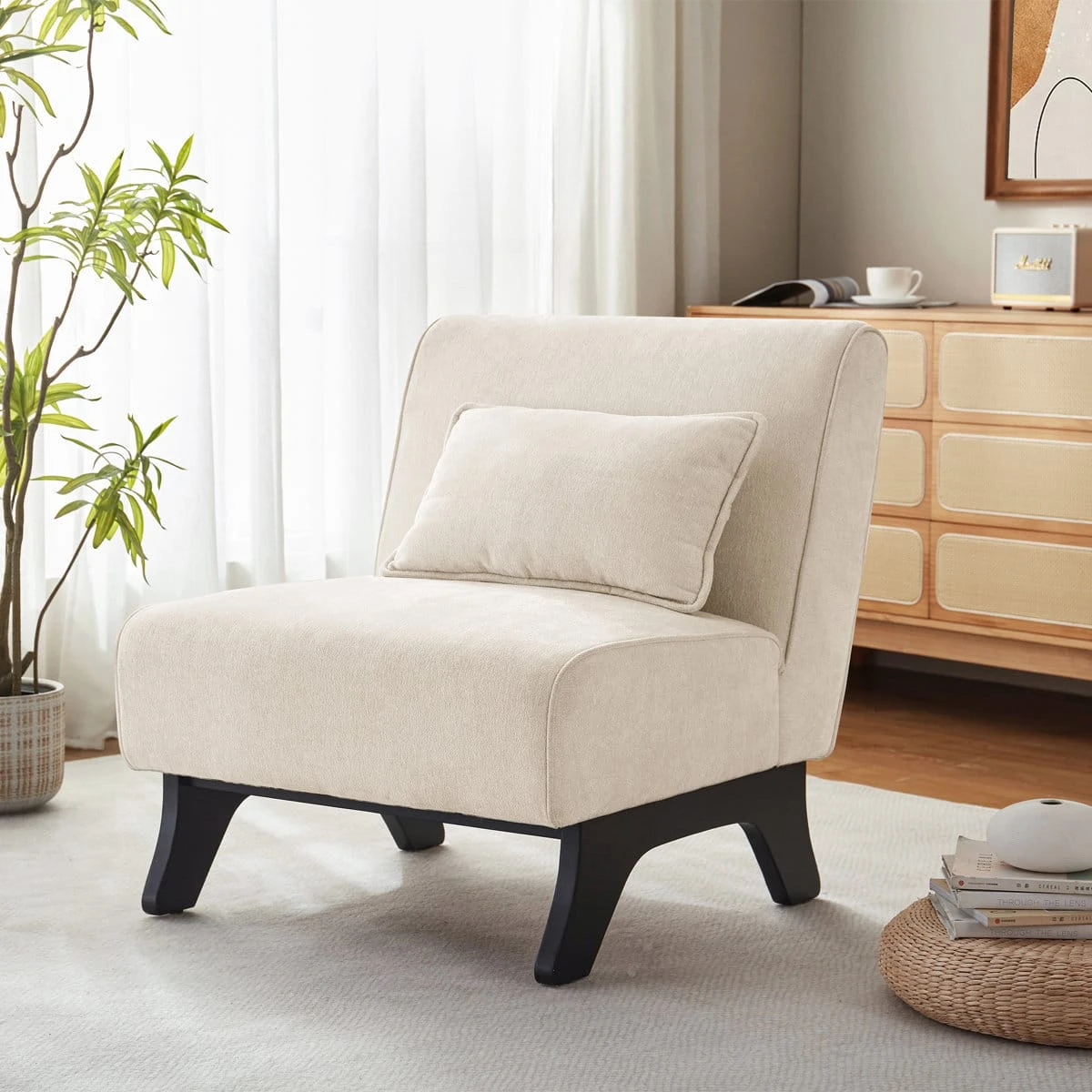 Three-quarter view of the cream chair with pillow in a bright living room setting
