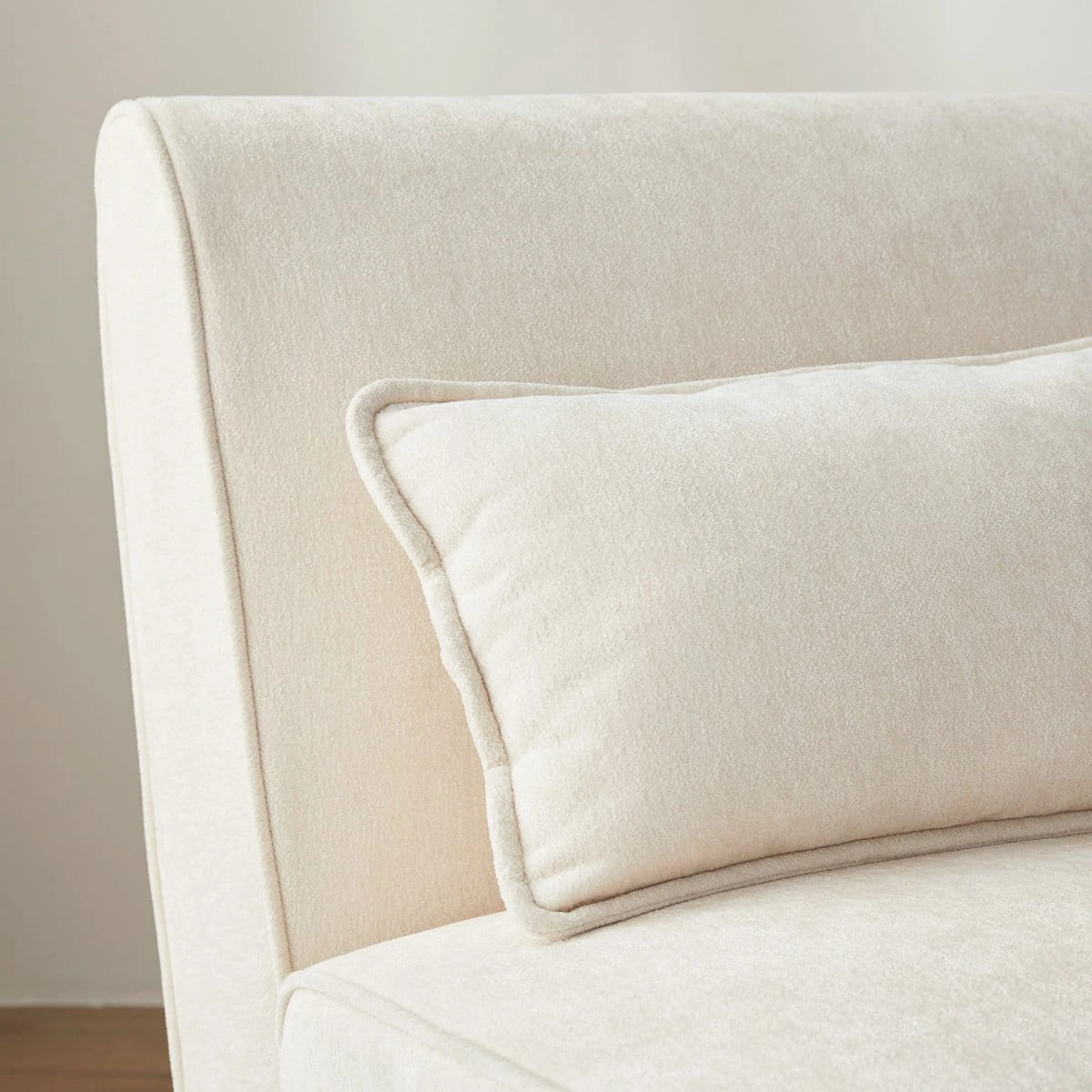 Close-up of the curved chair back and detachable cream lumbar pillow