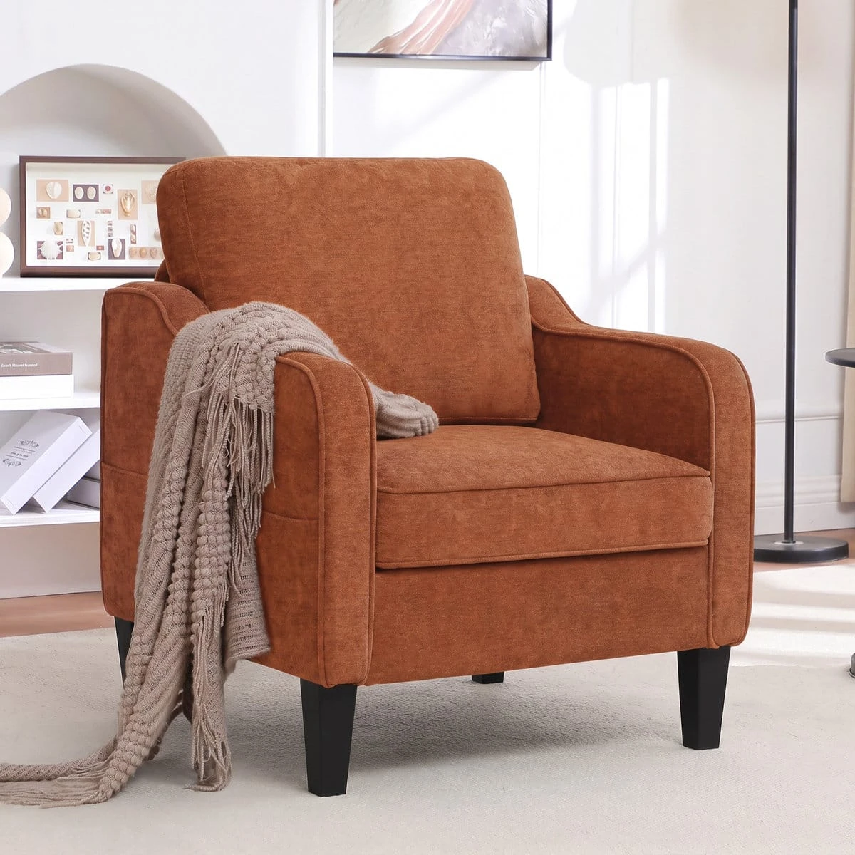 Accent chair styled with a beige knitted throw draped over the left armrest