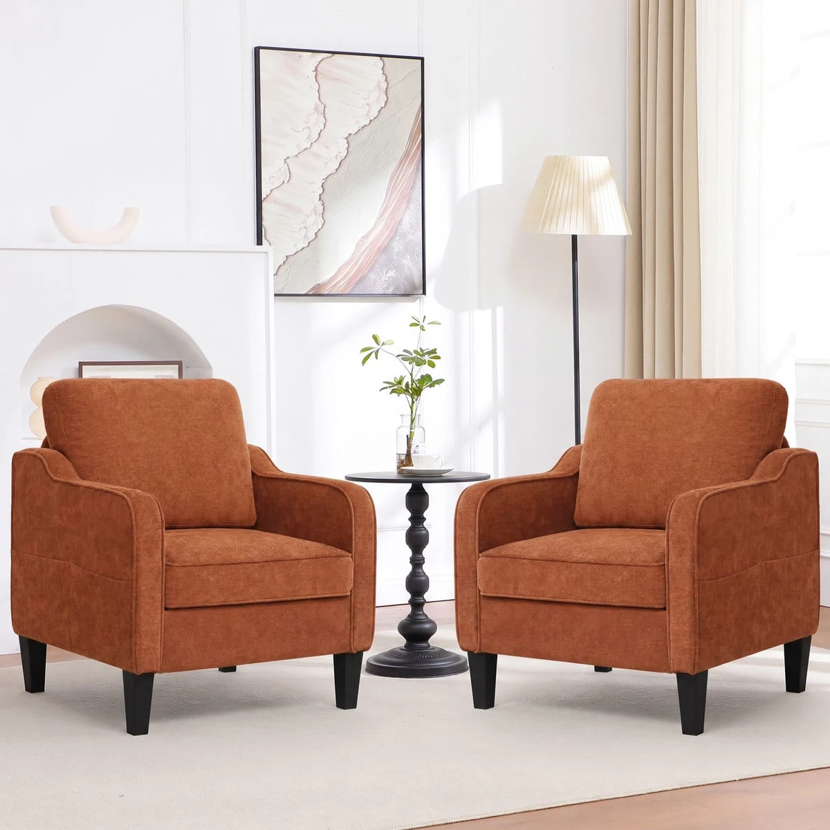 Two matching rust brown armchairs arranged with a black round side table between them