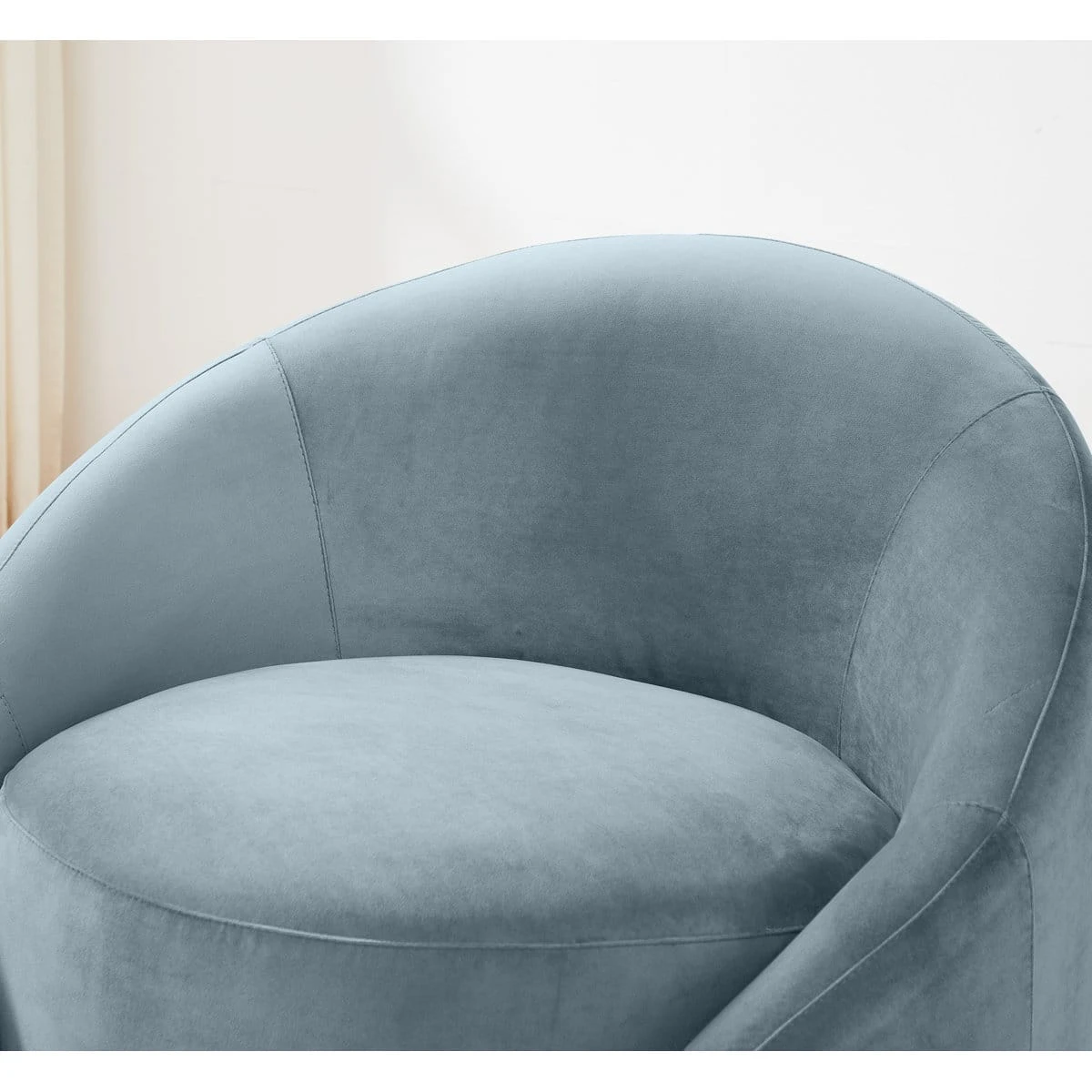 Close-up of the plush seat and wraparound backrest with smooth light blue upholstery and seam details