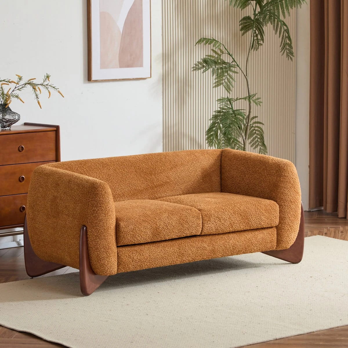 Loveseat styled in a living room on a light rug, showing textured upholstery and curved form