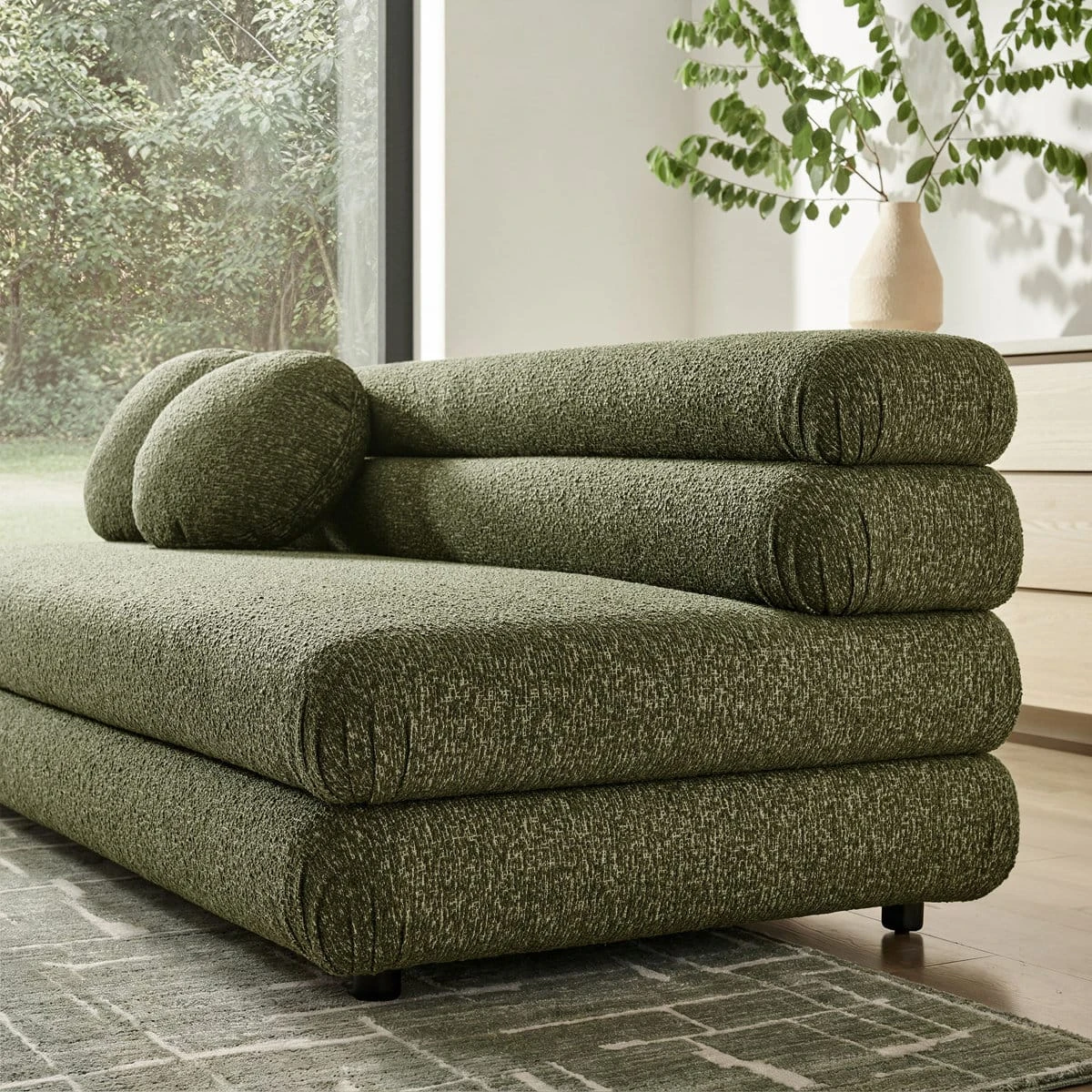 Rear side angle highlighting the layered cylindrical backrest and textured olive upholstery