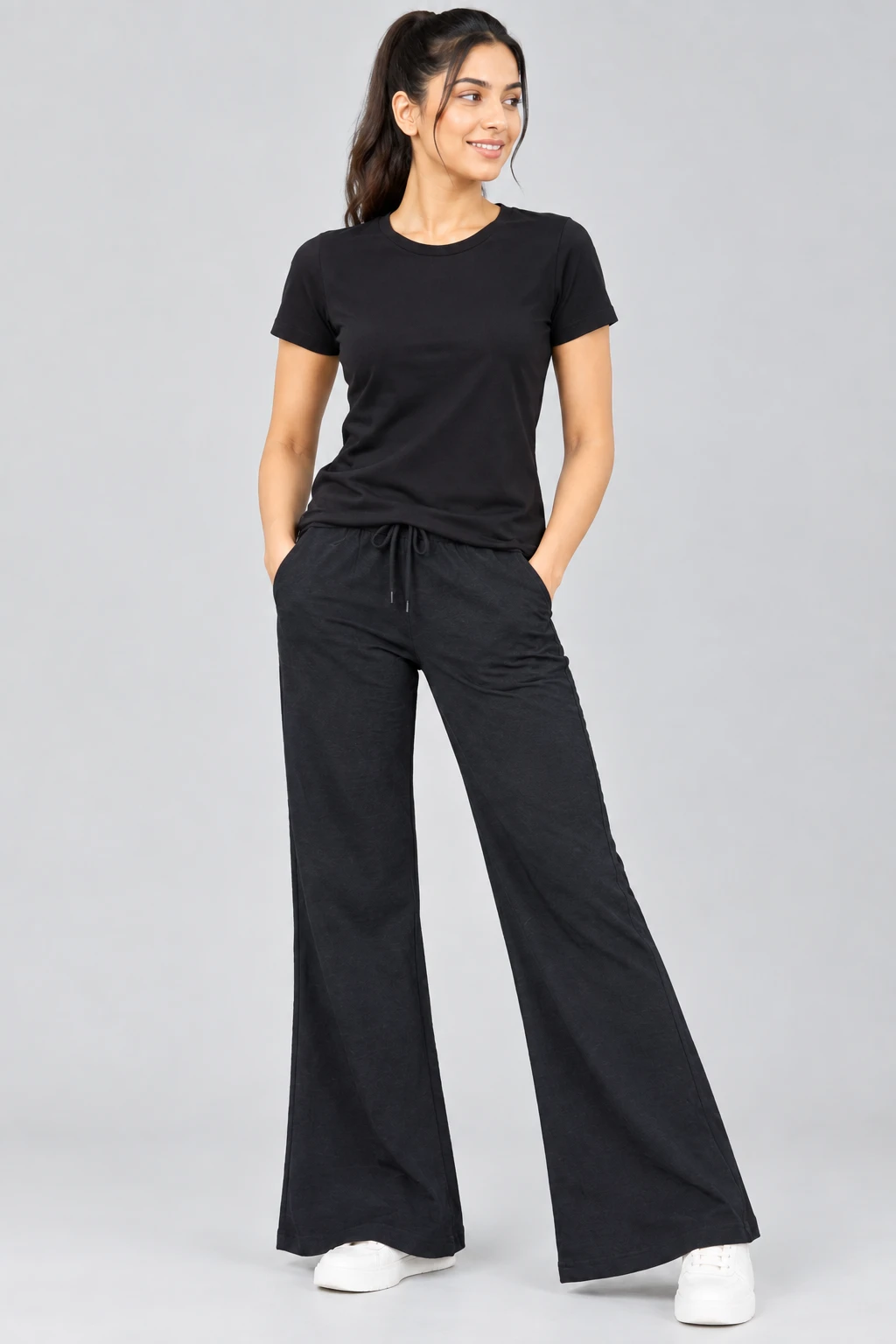 Front view of black co-ord set with crew-neck tee and wide-leg drawstring pants worn with white sneakers