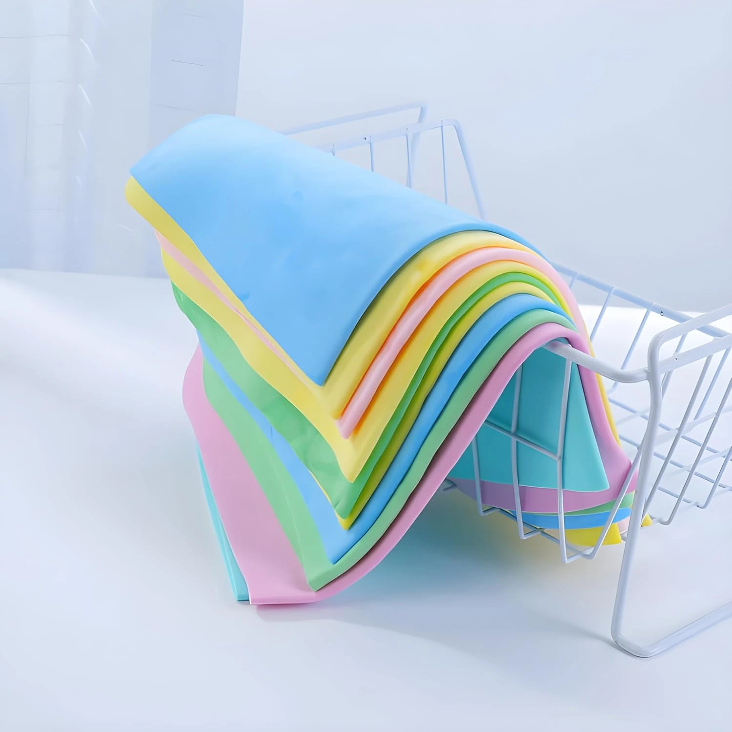 Stack of pastel shammy towels draped over a white drying rack