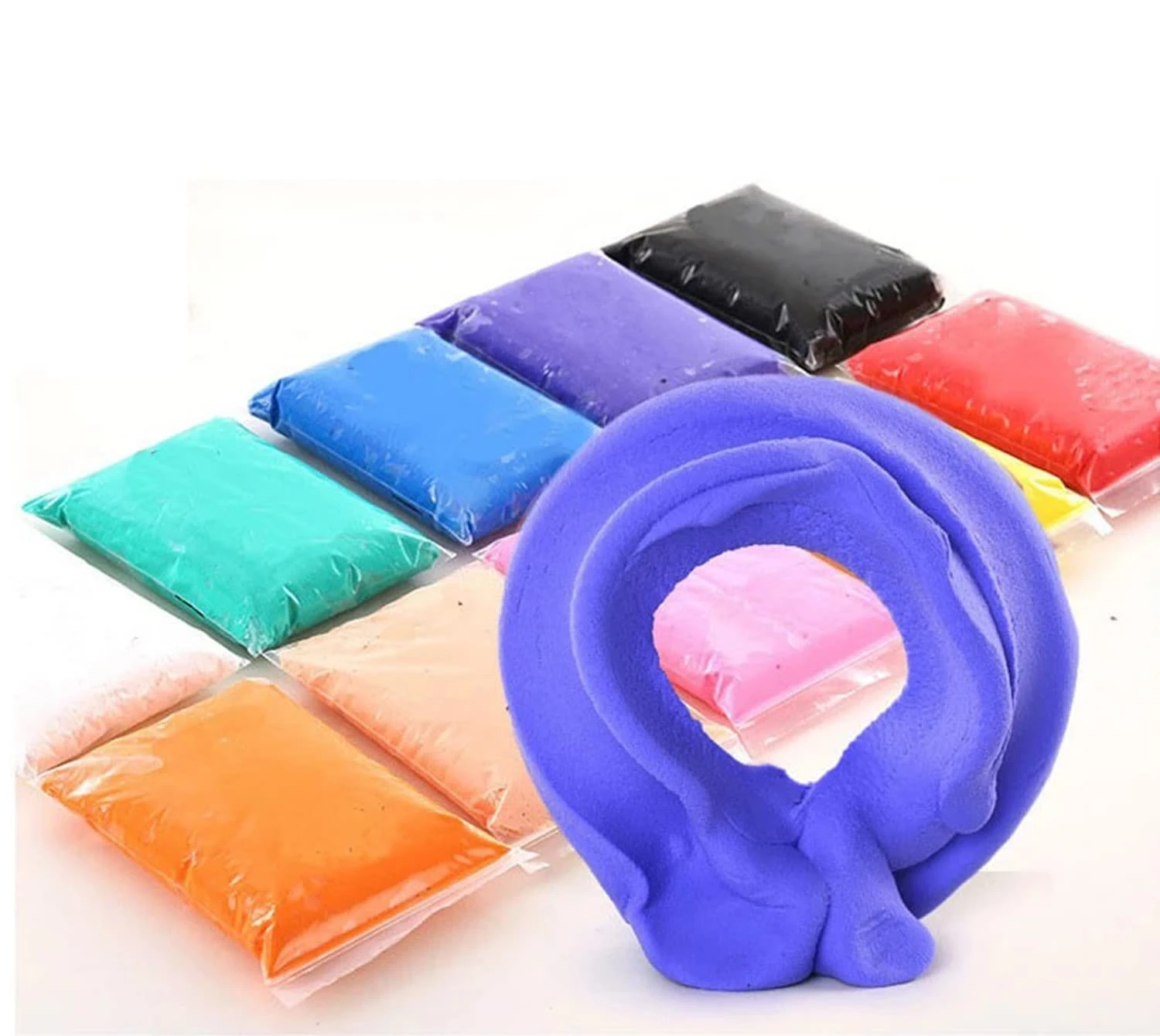 Purple clay rolled into a loop in front of assorted colored clay packets sealed in clear plastic