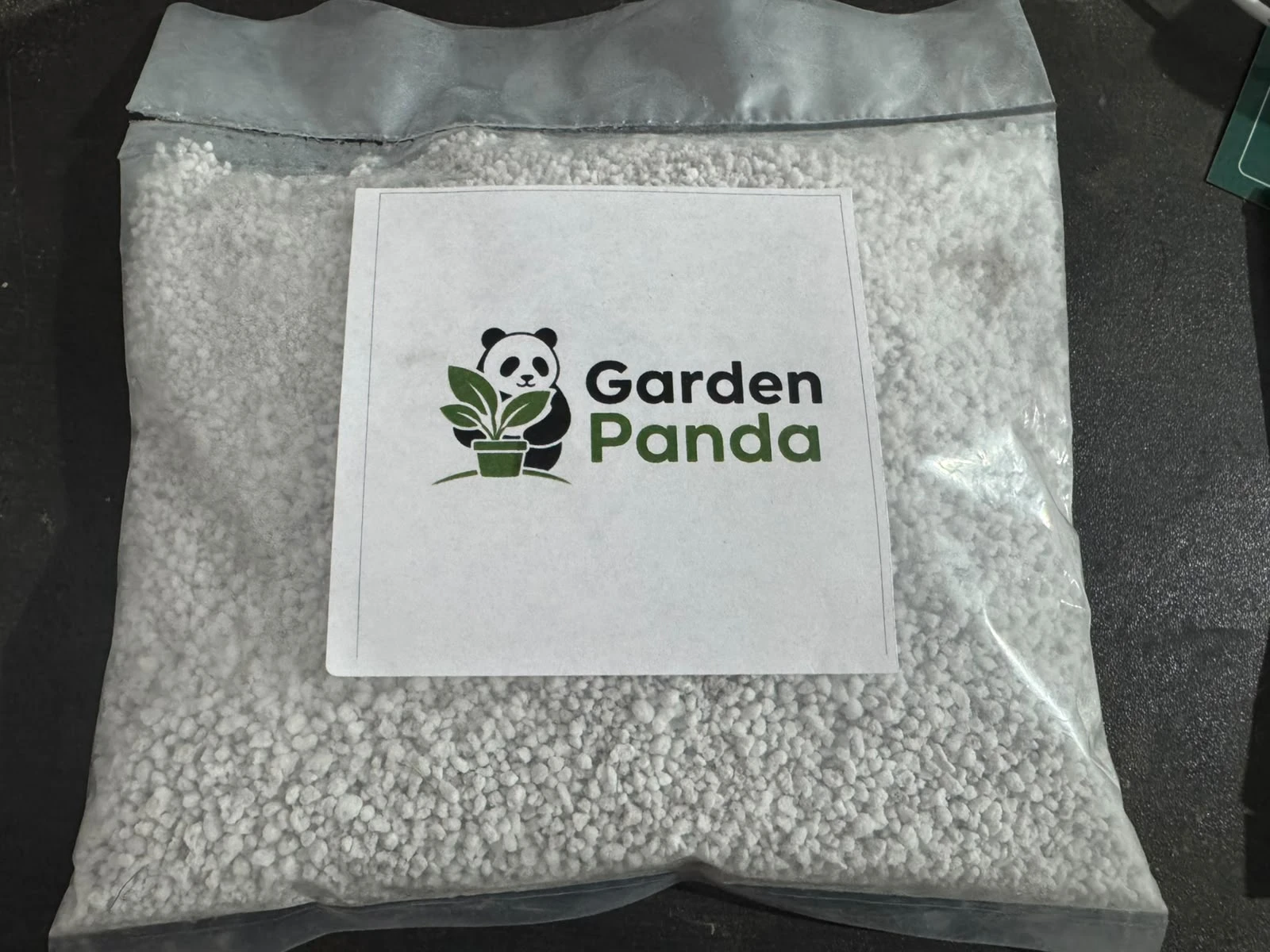 Top-down close-up of sealed Garden Panda perlite pouch showing white granules through clear plastic