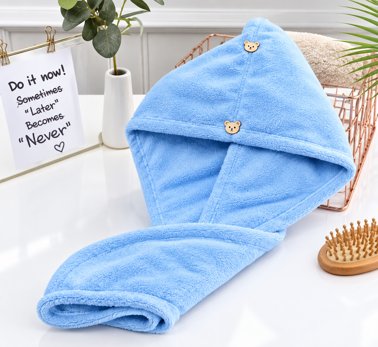 Blue microfiber hair wrap towel draped over a rose gold basket, with bear-shaped buttons on a vanity
