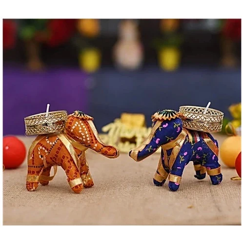 Two elephant candle holders in orange and blue fabric shown side by side with empty metal cups