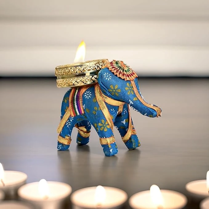 Close-up of a blue elephant tea light holder with a lit candle and blurred tealights in front