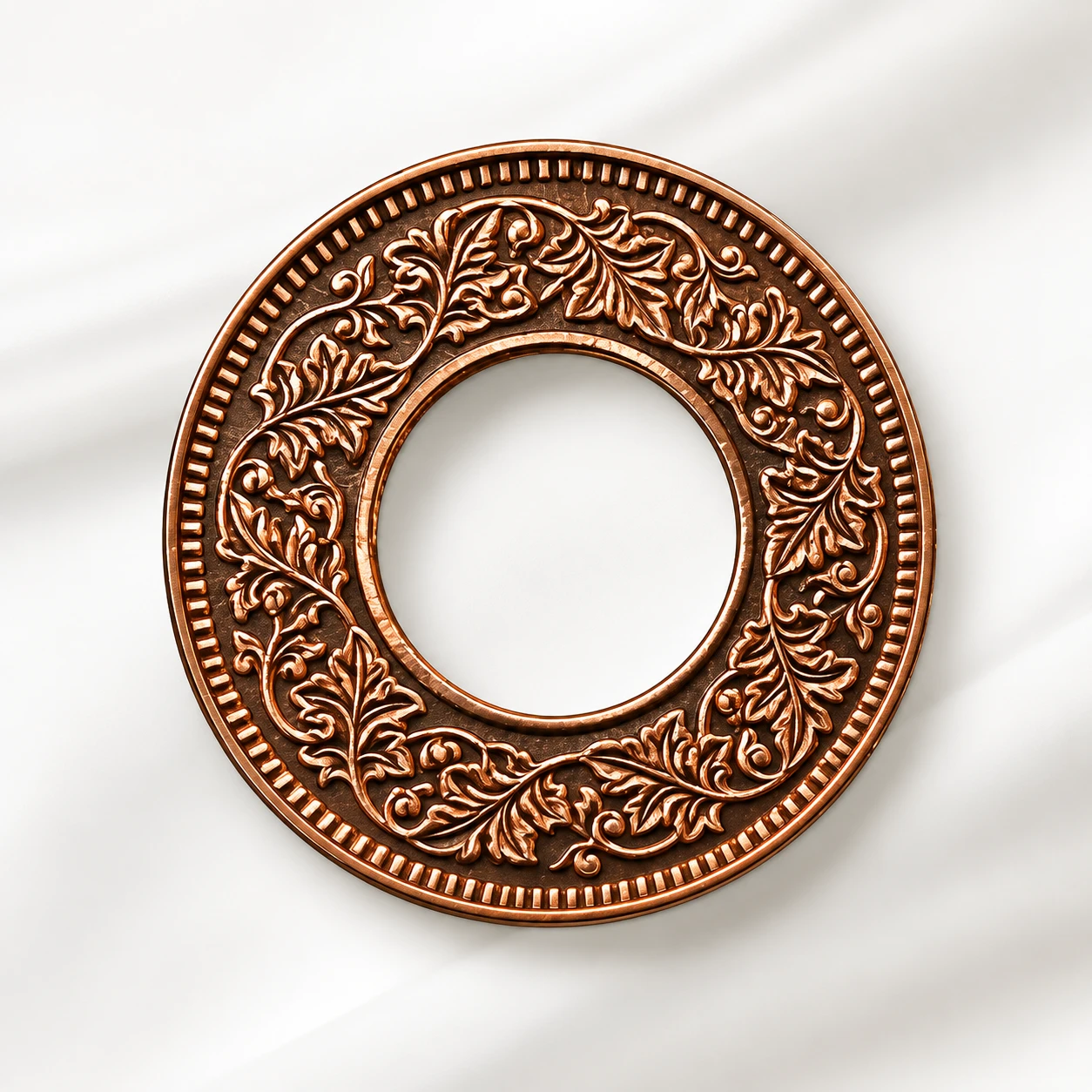 Copper-toned holed coin side showing ornate floral vine engraving and beaded outer border