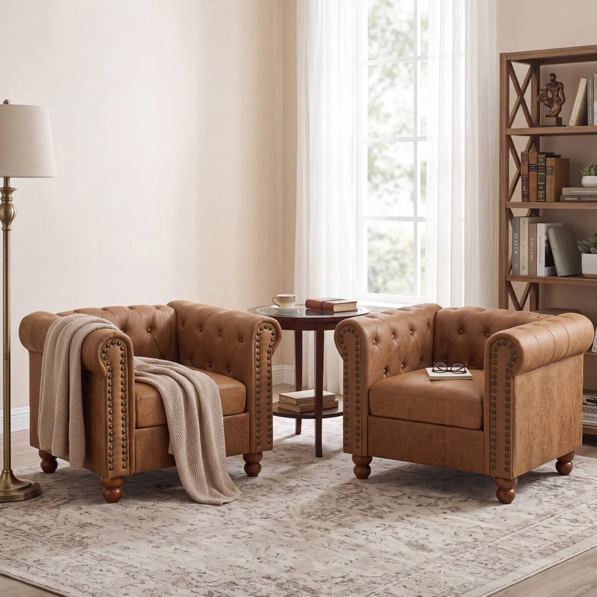 Two matching tan brown Chesterfield armchairs with nailhead arms and round wooden legs