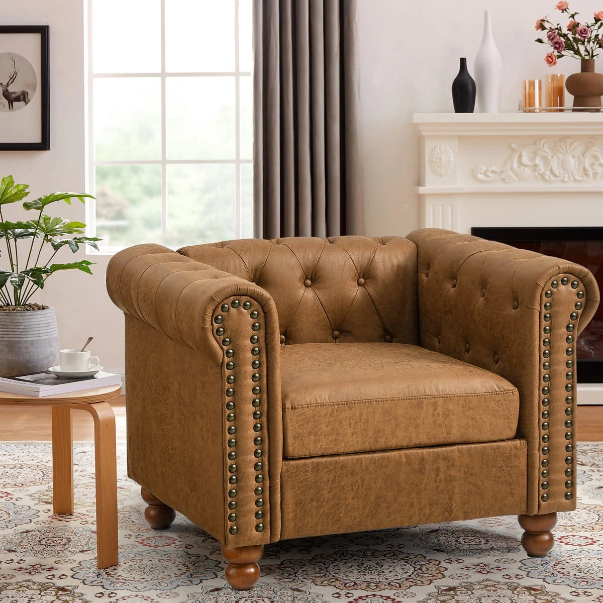 Front view of the tan brown Chesterfield armchair styled by a fireplace, showing deep seat and rolled arms
