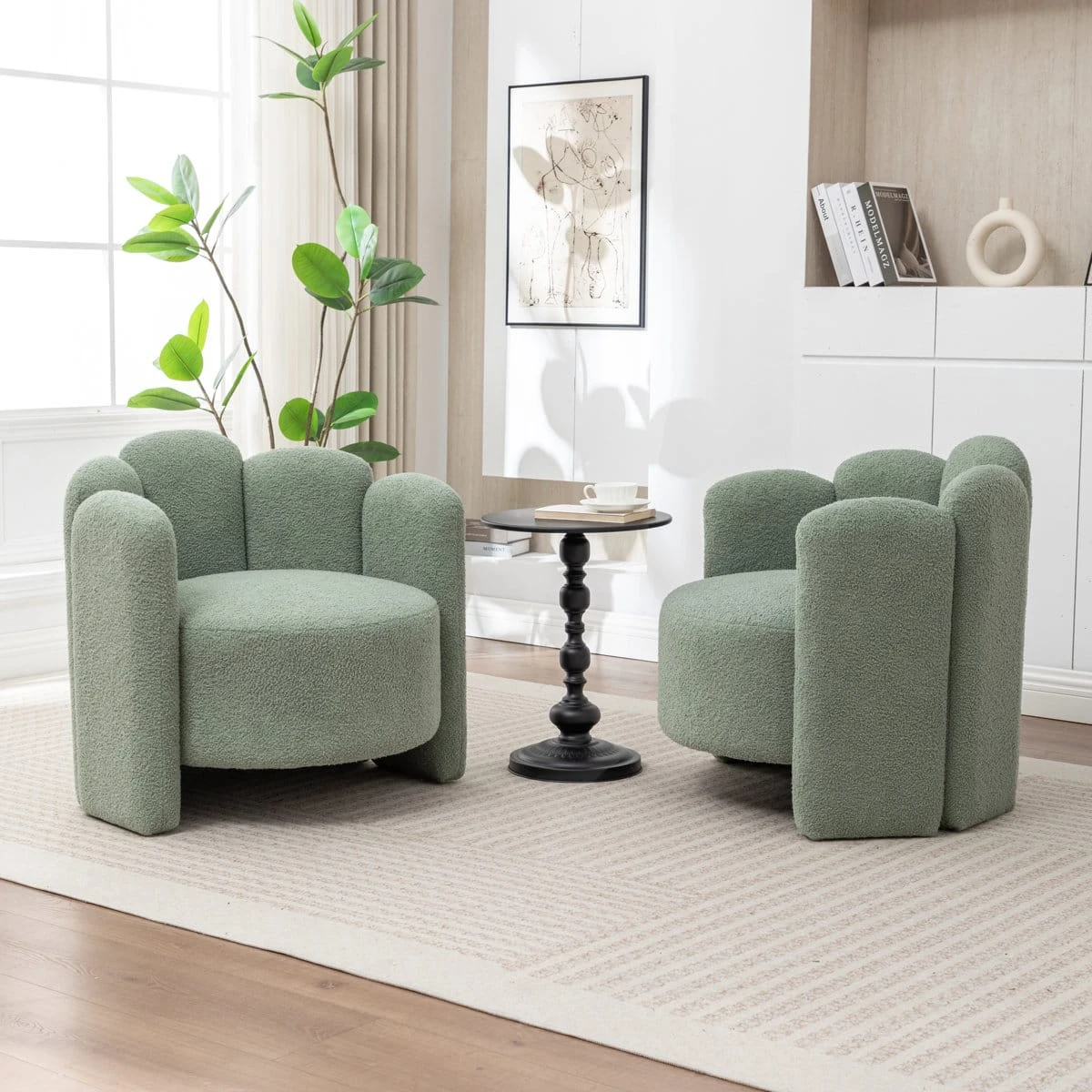 Two sage green boucle armchairs styled in a living room with a black side table