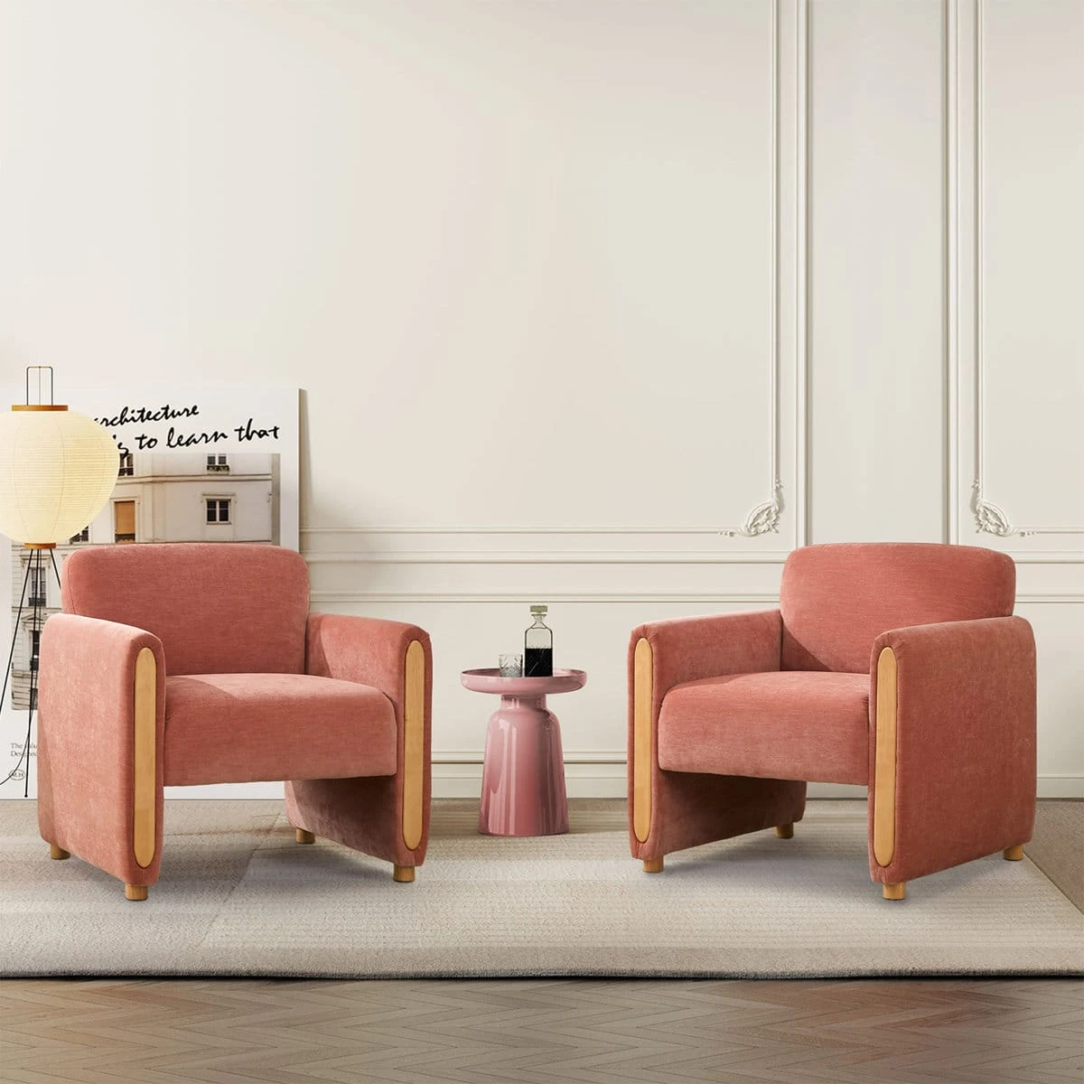 Two matching pink accent chairs styled in a living room beside a small round side table