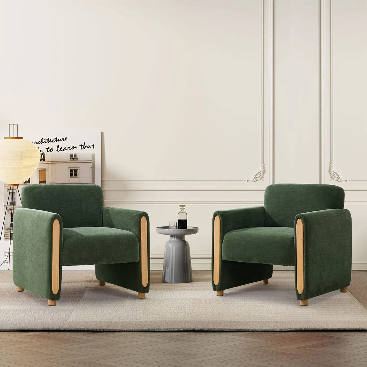 Two matching green accent chairs staged in a living room beside a small round side table