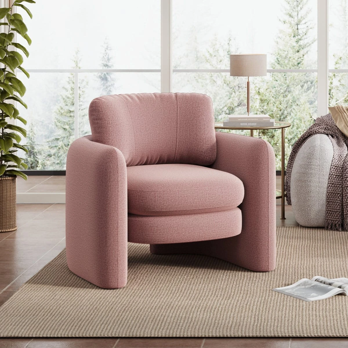 Blush pink accent armchair on a beige rug in a bright living room, shown from the front-left angle