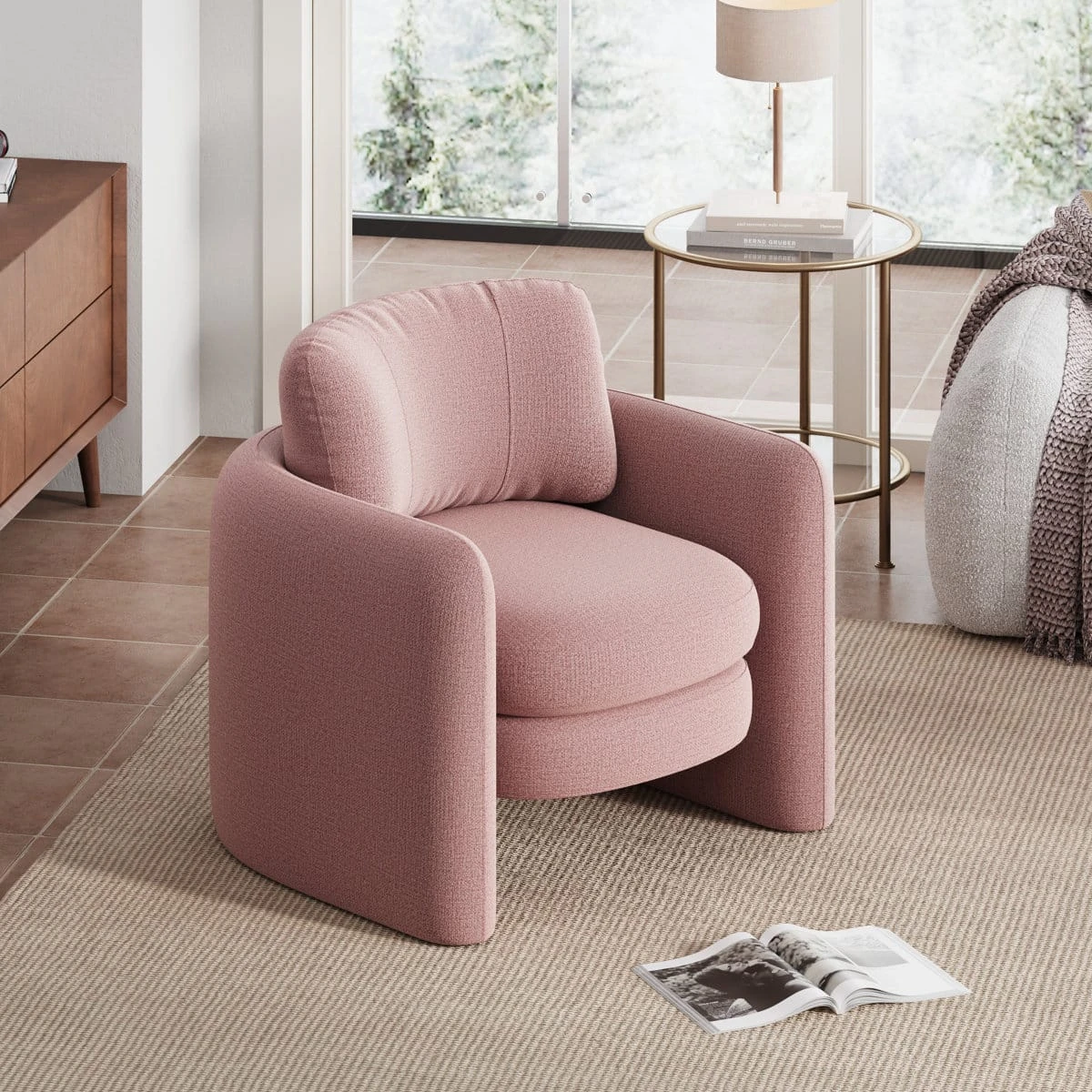 Angled room view of the pink upholstered chair beside a side table and open magazine
