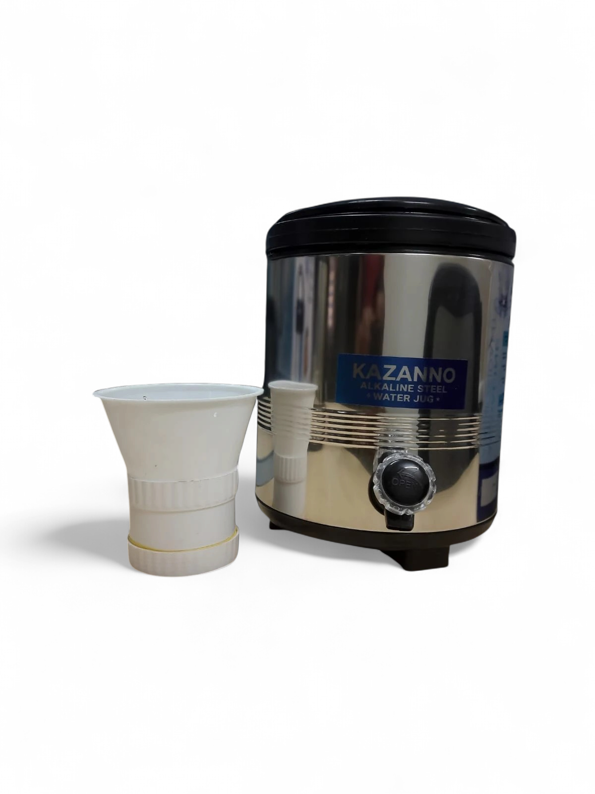 Closer angled view of the polished jug body and dispensing tap with folded white cup in front