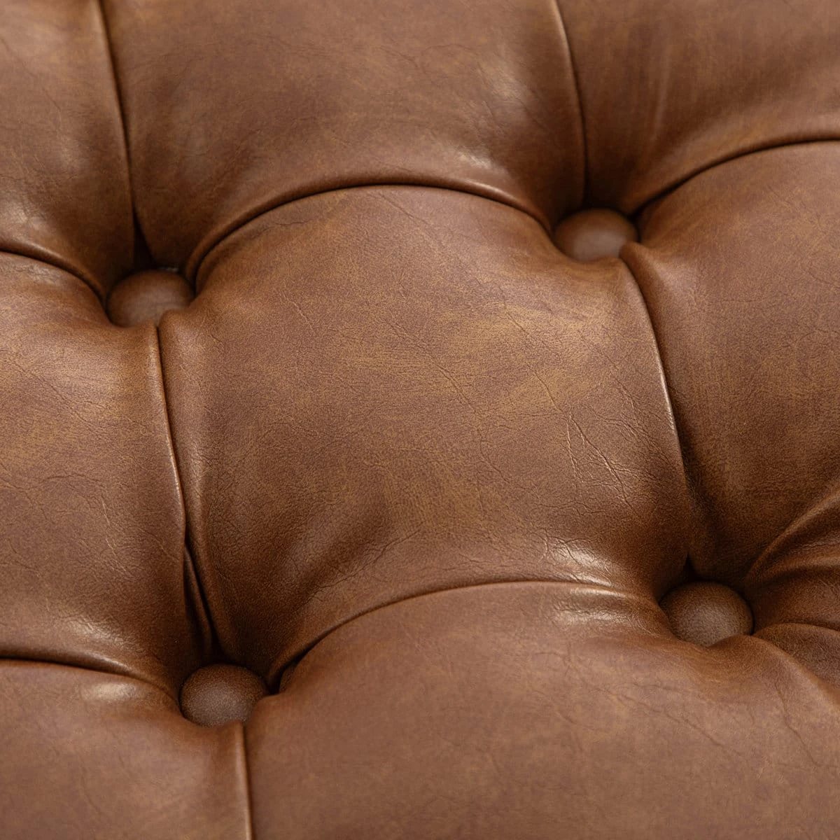 Close-up of the brown tufted faux leather seat with deep button detailing