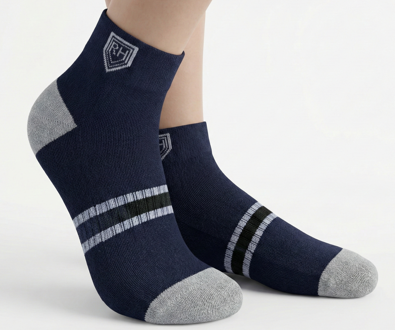 Navy ankle socks worn on feet, with grey toe and heel, twin white stripes and dark green band