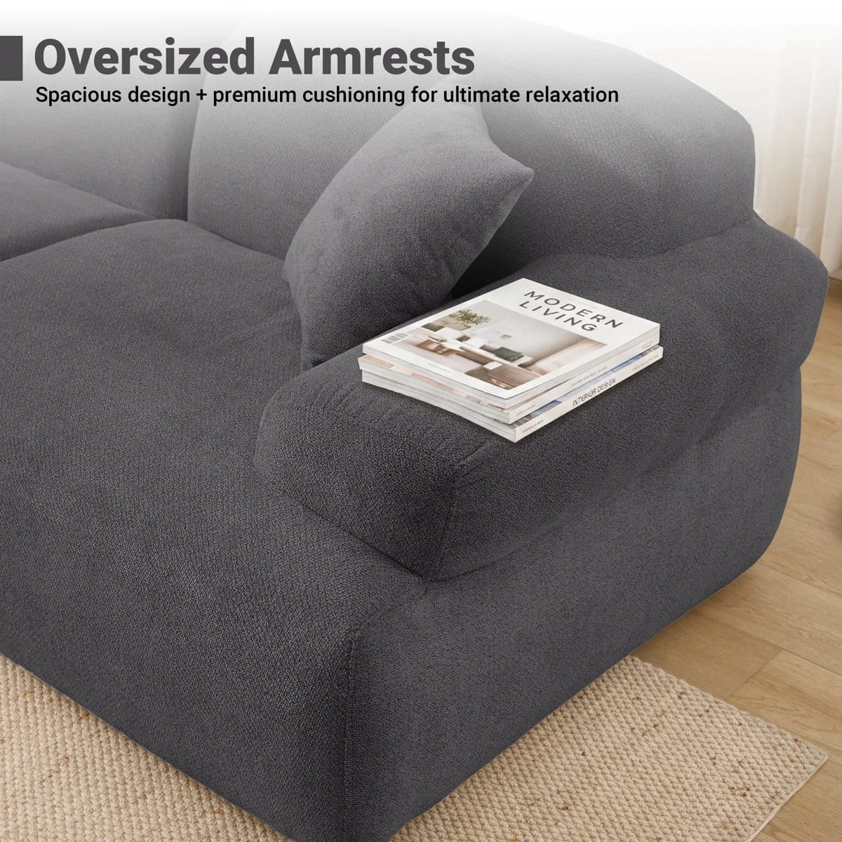 Close-up of oversized armrest with matching cushion and books resting on the dark grey fabric surface