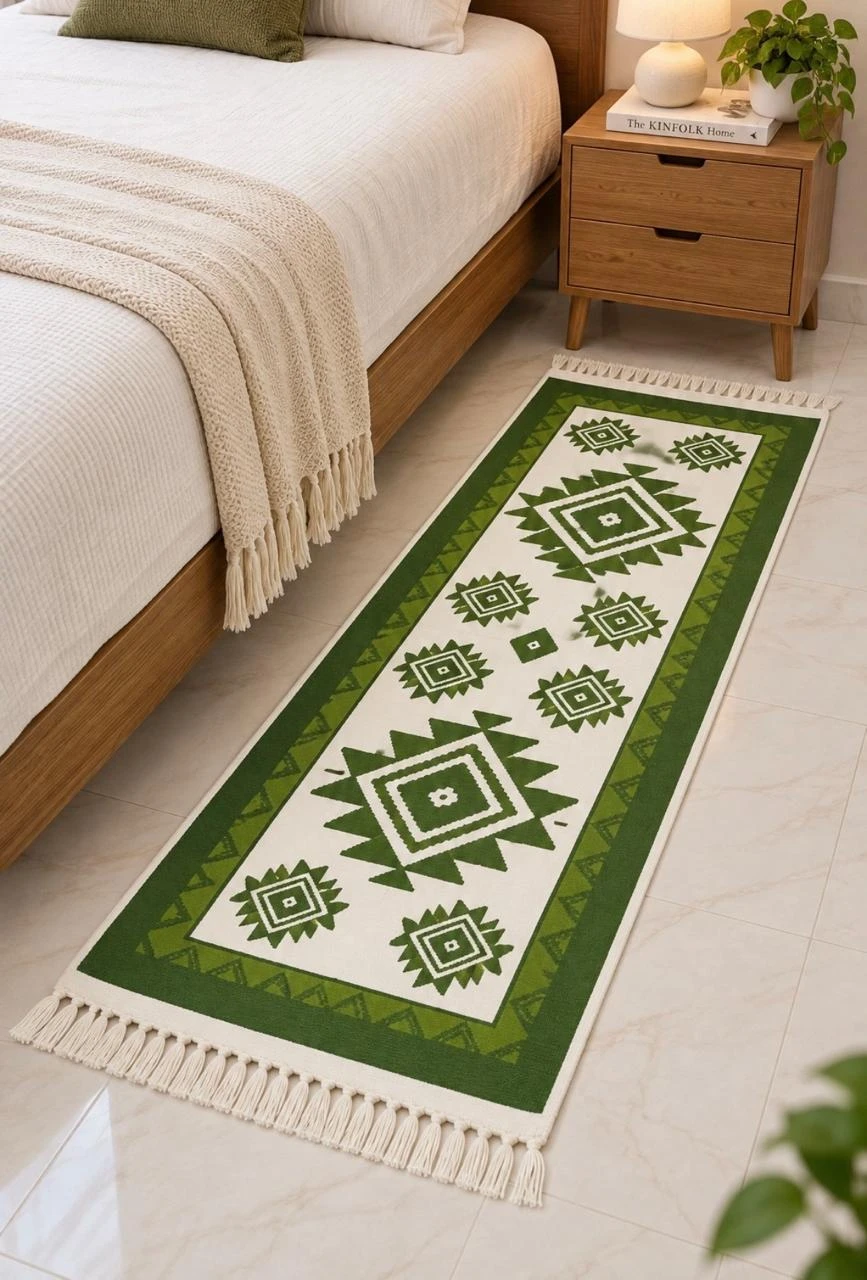 Green and cream geometric runner rug with tassel fringe placed beside a wooden bed and nightstand