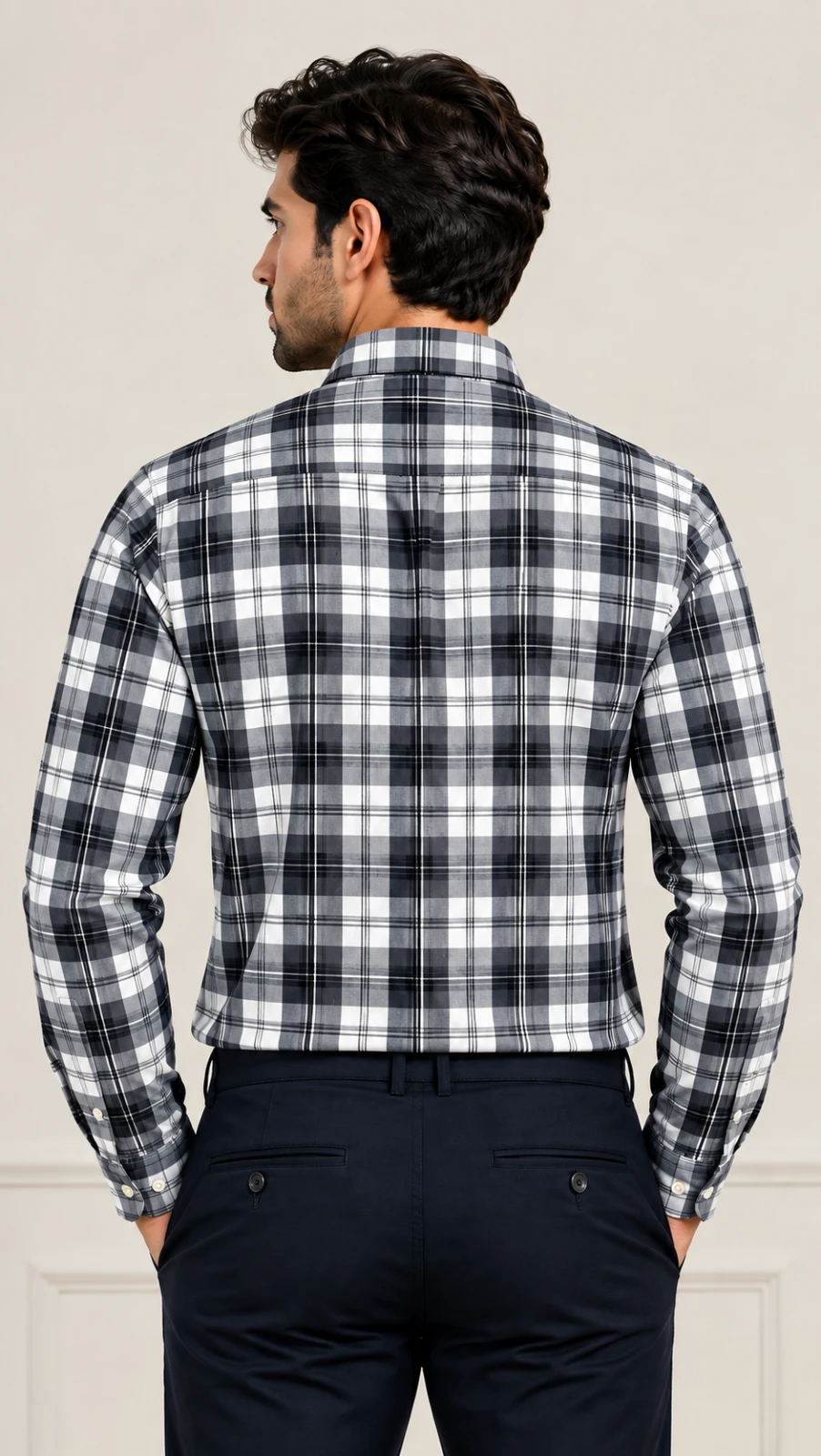 Back view of a men's grey, white and black plaid shirt tucked into navy trousers