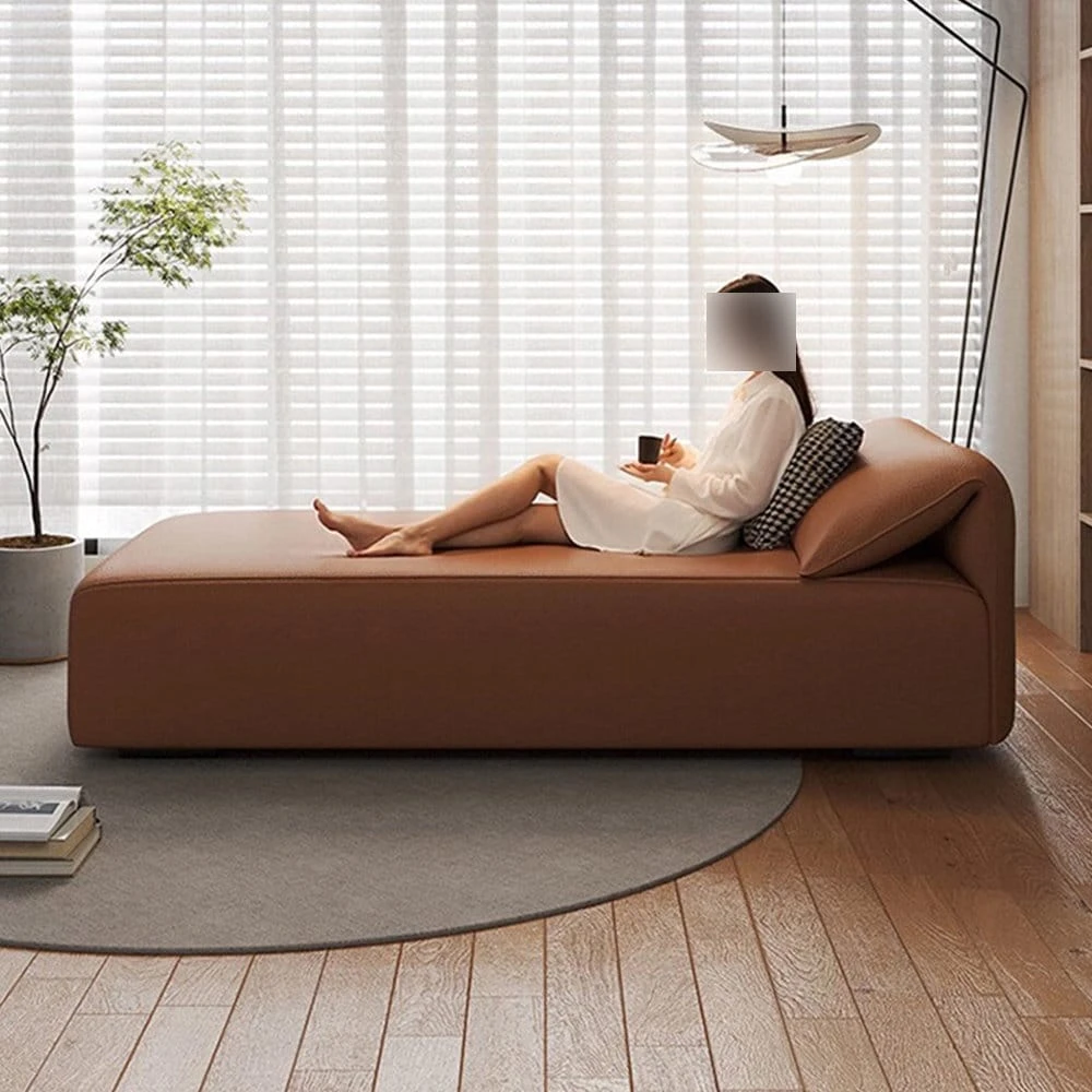 Side profile of the chaise lounge in use, showing the raised backrest and full-length cushioned seat