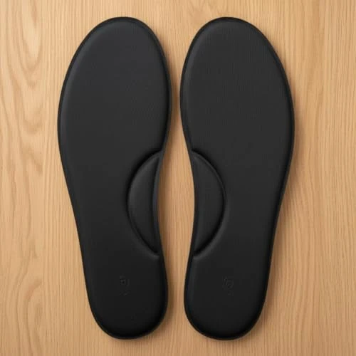 Top view of the black insole pair laid flat side by side on a wooden surface