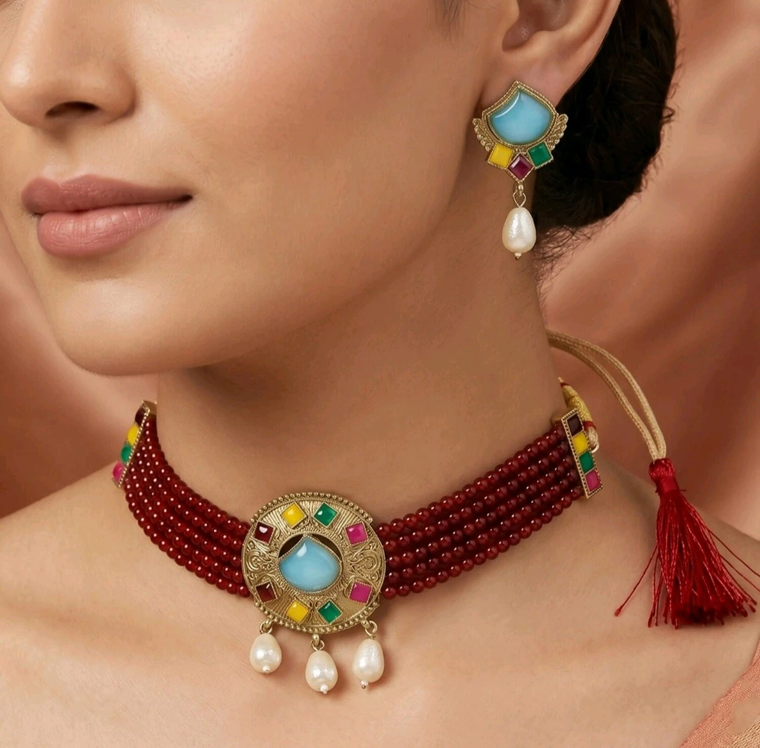 Close-up of maroon beaded choker worn on model, showing blue center stone, multicolor accents, pearl drops and earring