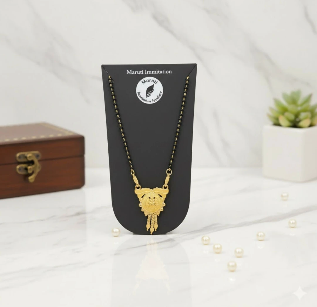 Gold-tone pendant mangalsutra on stand with marble backdrop, box, and small pearls