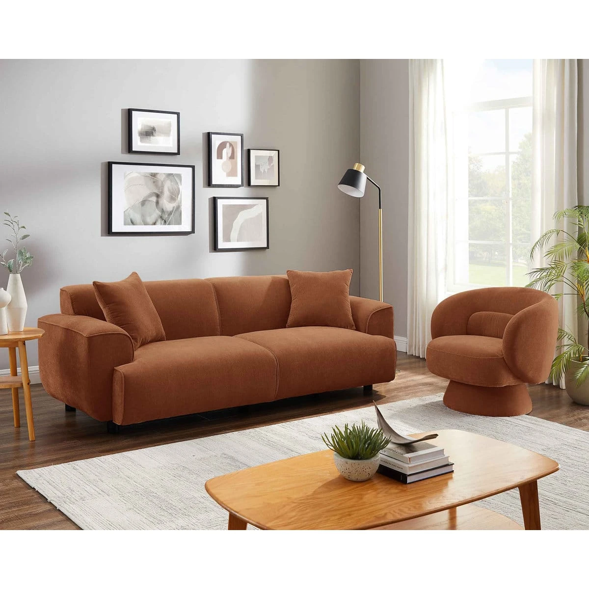 Angled living room view of the pink sofa and matching swivel chair beside large windows