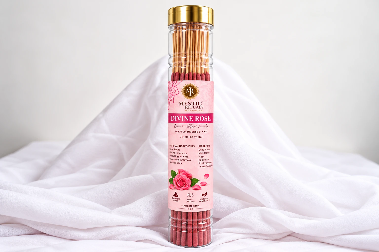 Divine Rose incense tube with pink label, gold cap, and rose graphic, standing on draped white fabric