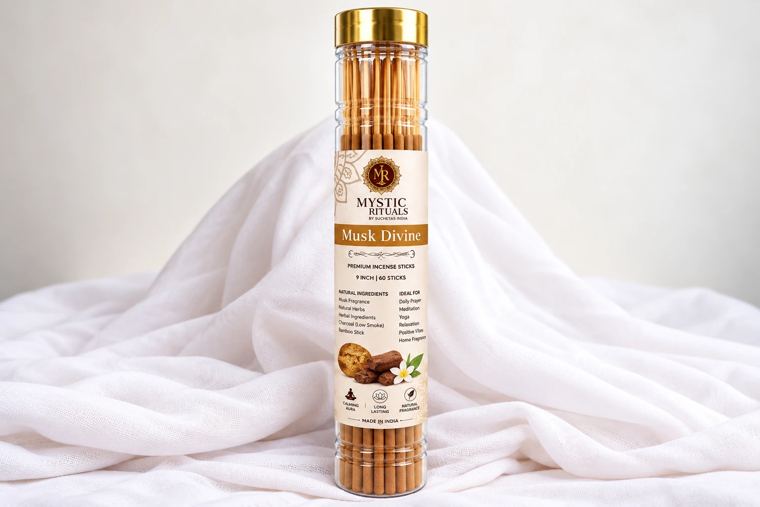 Musk Divine incense tube with beige label, gold cap, and wood-and-flower graphic on white draped cloth