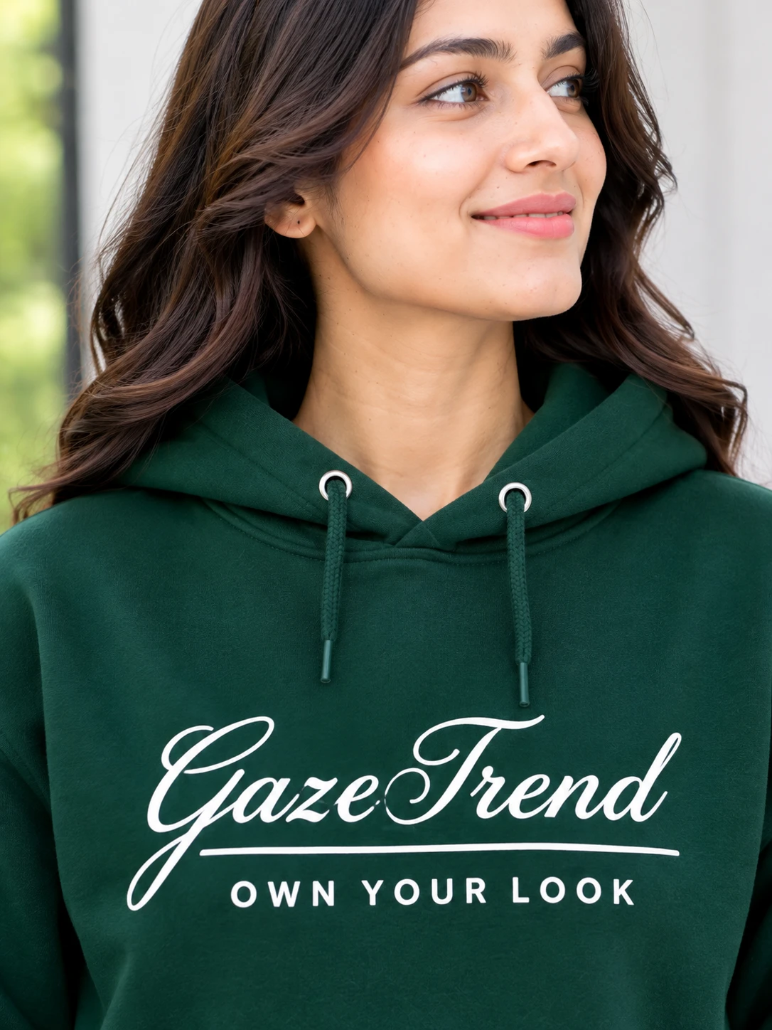 Close-up of hoodie chest print, hood, and drawstrings in dark green fabric