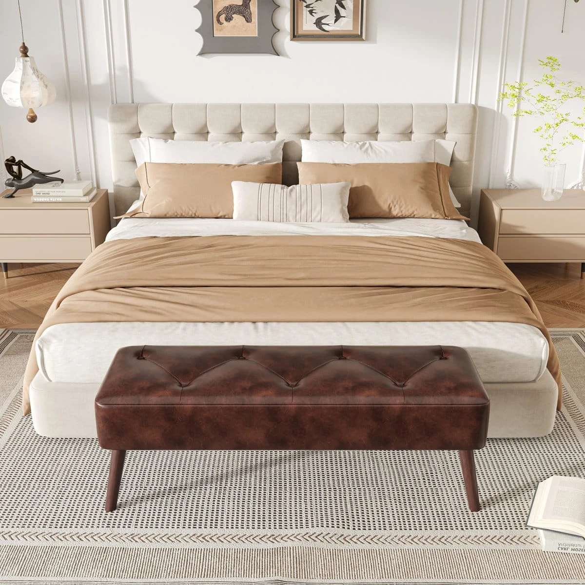 Brown tufted storage ottoman placed at the foot of a bed in a styled bedroom
