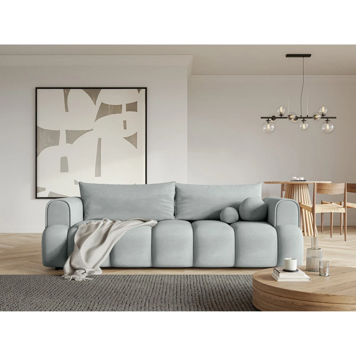 Light grey sofa styled in a living room with a throw blanket draped over the front seat