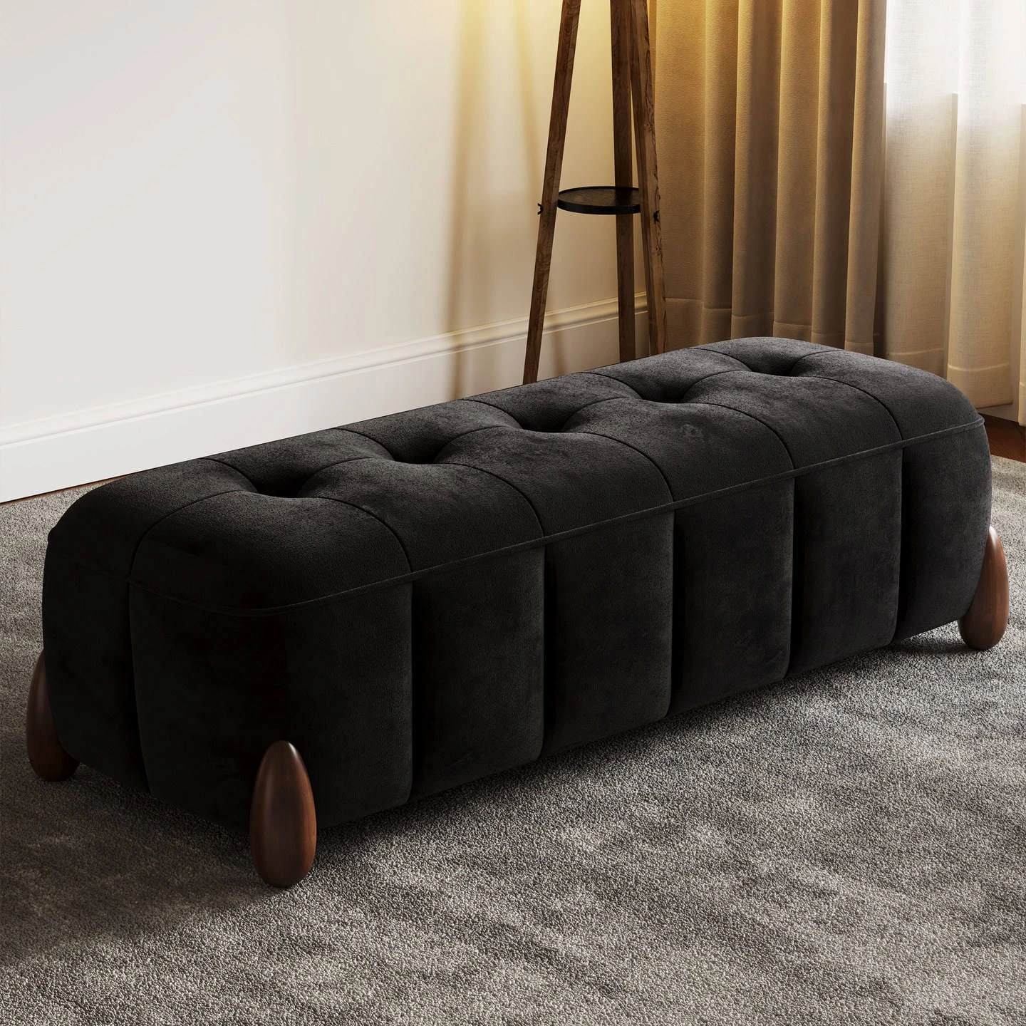 Black fabric bench ottoman in side angle view with plush tufting and tapered wooden legs