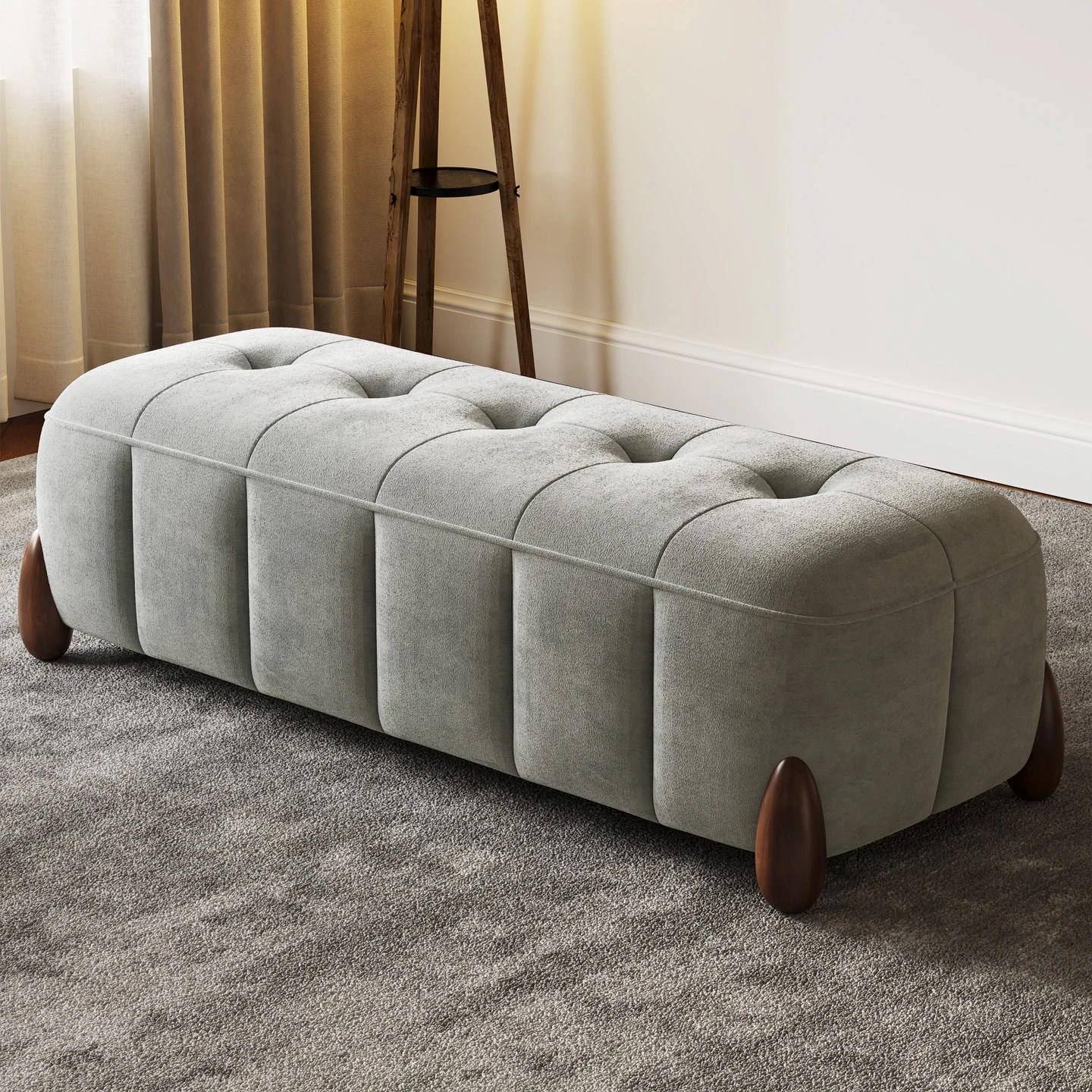 Light grey tufted storage-style bench ottoman displayed on carpet beside curtains