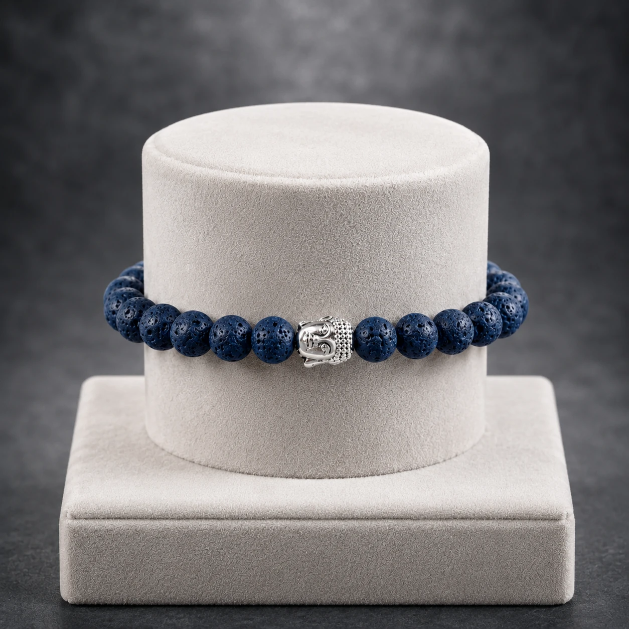 Front view of the bracelet wrapped around a cream velvet display stand against a gray background