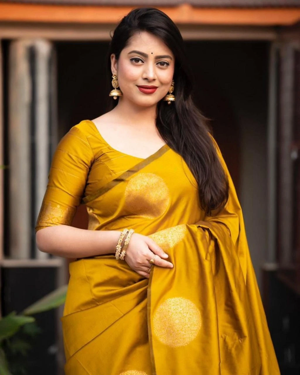 Mustard gold soft silk saree close-up with blouse sleeve and woven gold motif