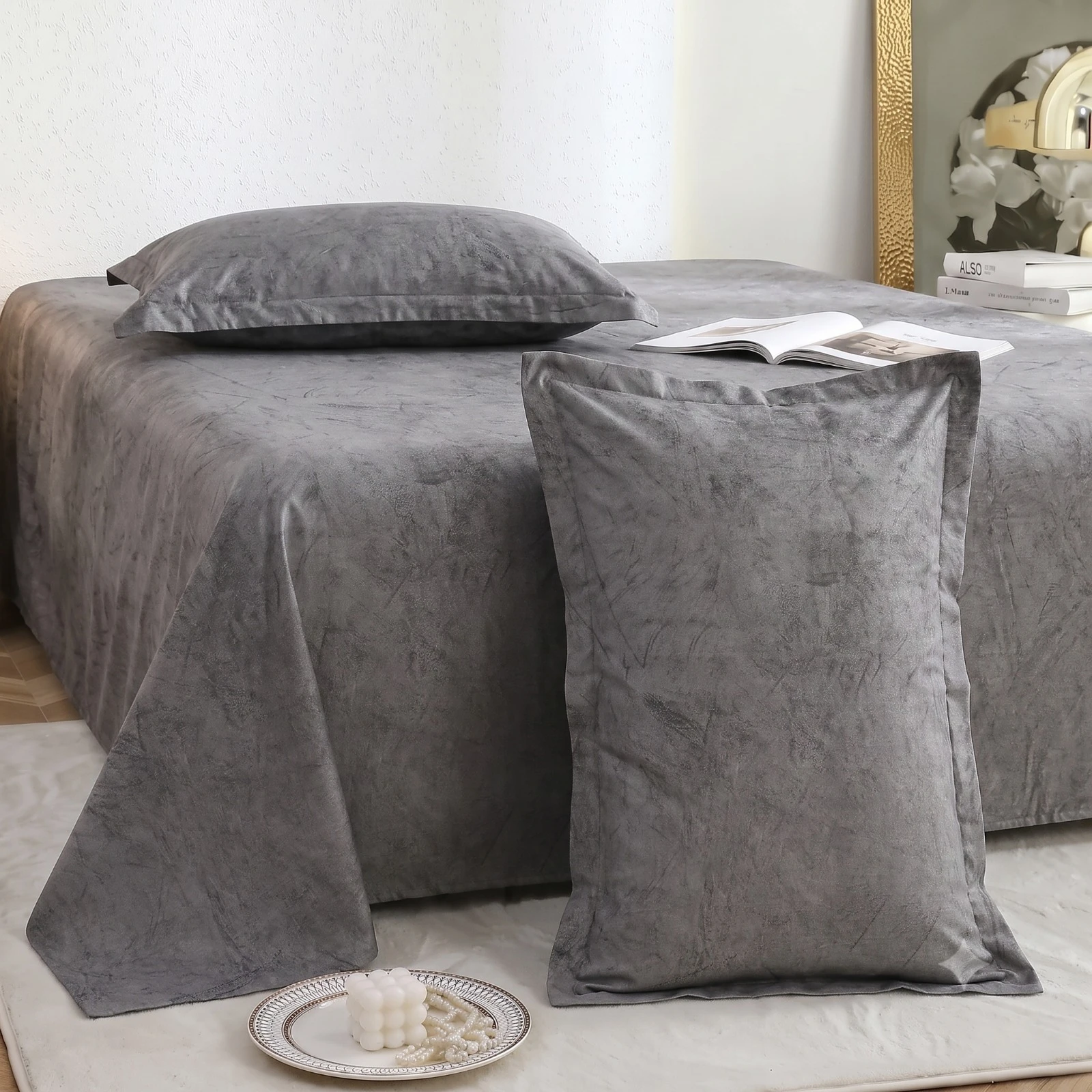 Angled close view showing the grey sheet drape and one matching pillow cover standing in front