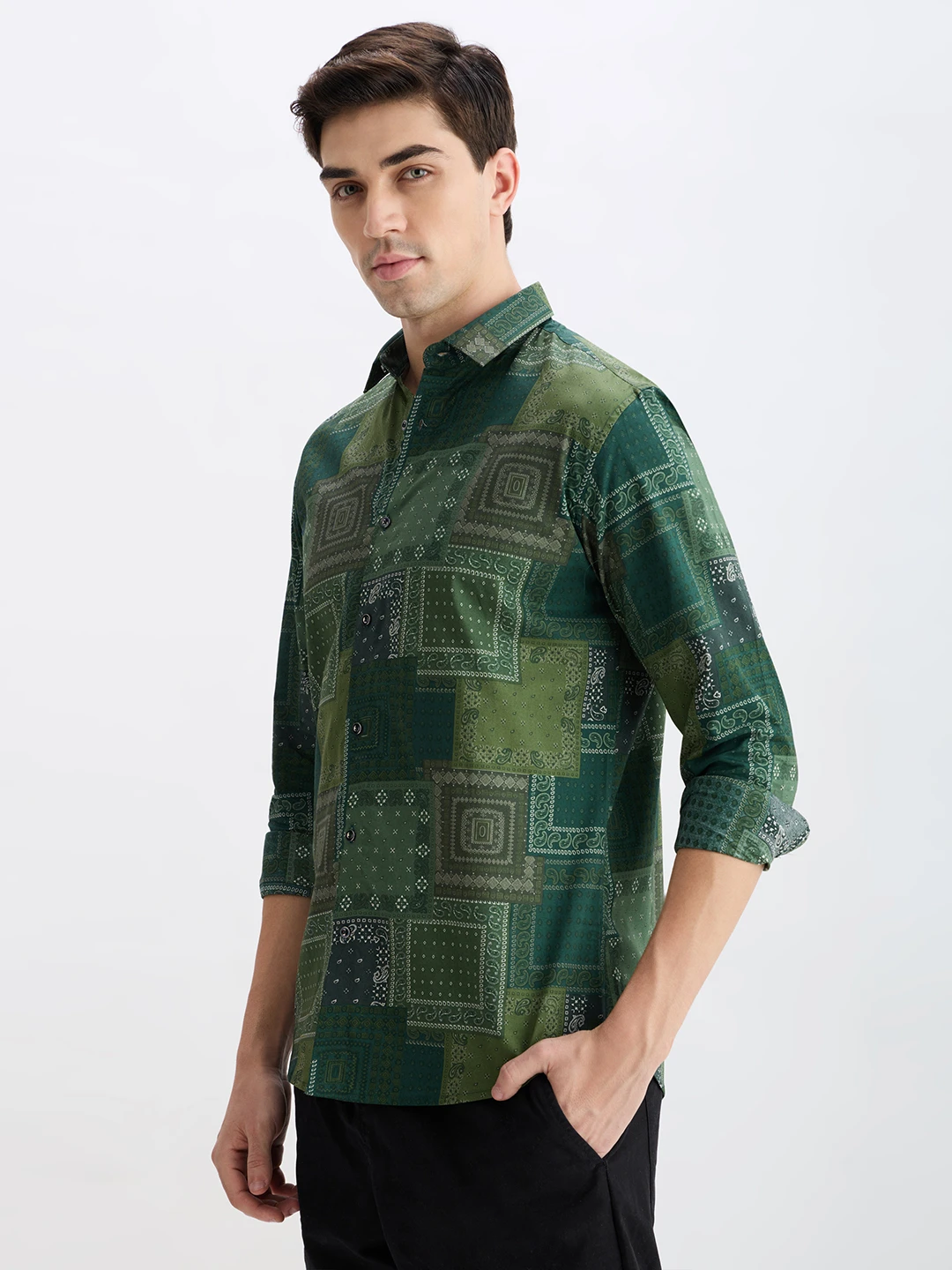 Three-quarter left view showing the green all-over print shirt with button front and collar