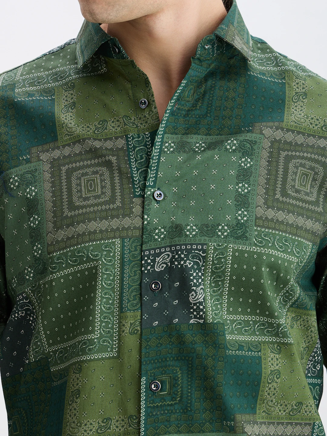 Close-up of collar, placket, buttons, and bandana-style patchwork print in green tones